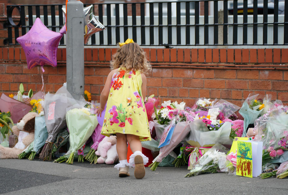 A young girl lays a tribute in Kingsheath Avenue, Knotty Ash, Liverpool, where nine-year-old Olivia Pratt-Korbel was fatally shot on Monday night. The people of Liverpool have been urged to turn in the masked gunman who killed Olivia as he chased his intended target into her home. Picture date: Wednesday August 24, 2022.