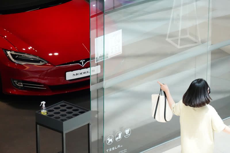 FILE PHOTO: A woman walks past a Tesla dealership in Hanam