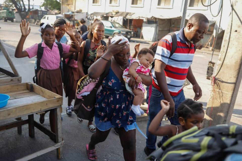 Residents flee their homes during clashes between police and gang member at the Portail neighborhood in Port-au-Prince, Haiti, Thursday, Feb. 29, 2024. Gunmen shot at the international airport and other targets in a wave of violence that forced businesses, government agencies and schools to close early. (AP Photo/Odelyn Joseph)