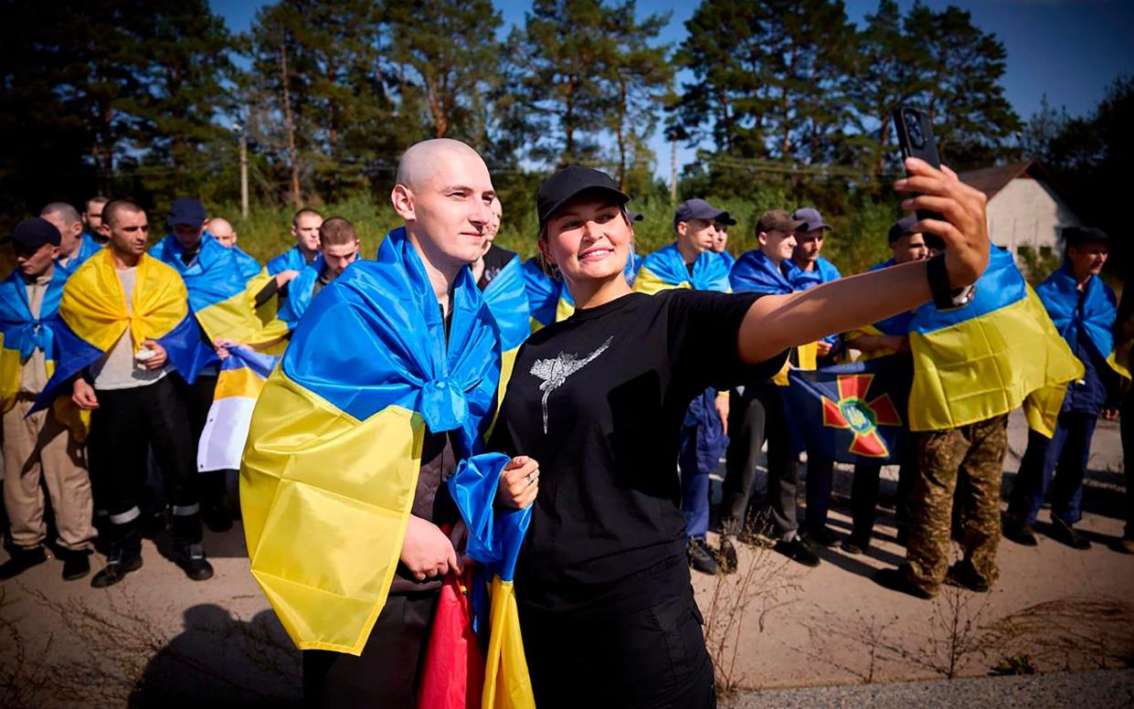 A Ukrainian poses for a selfie as he is greeted after being released in a prisoner exchange