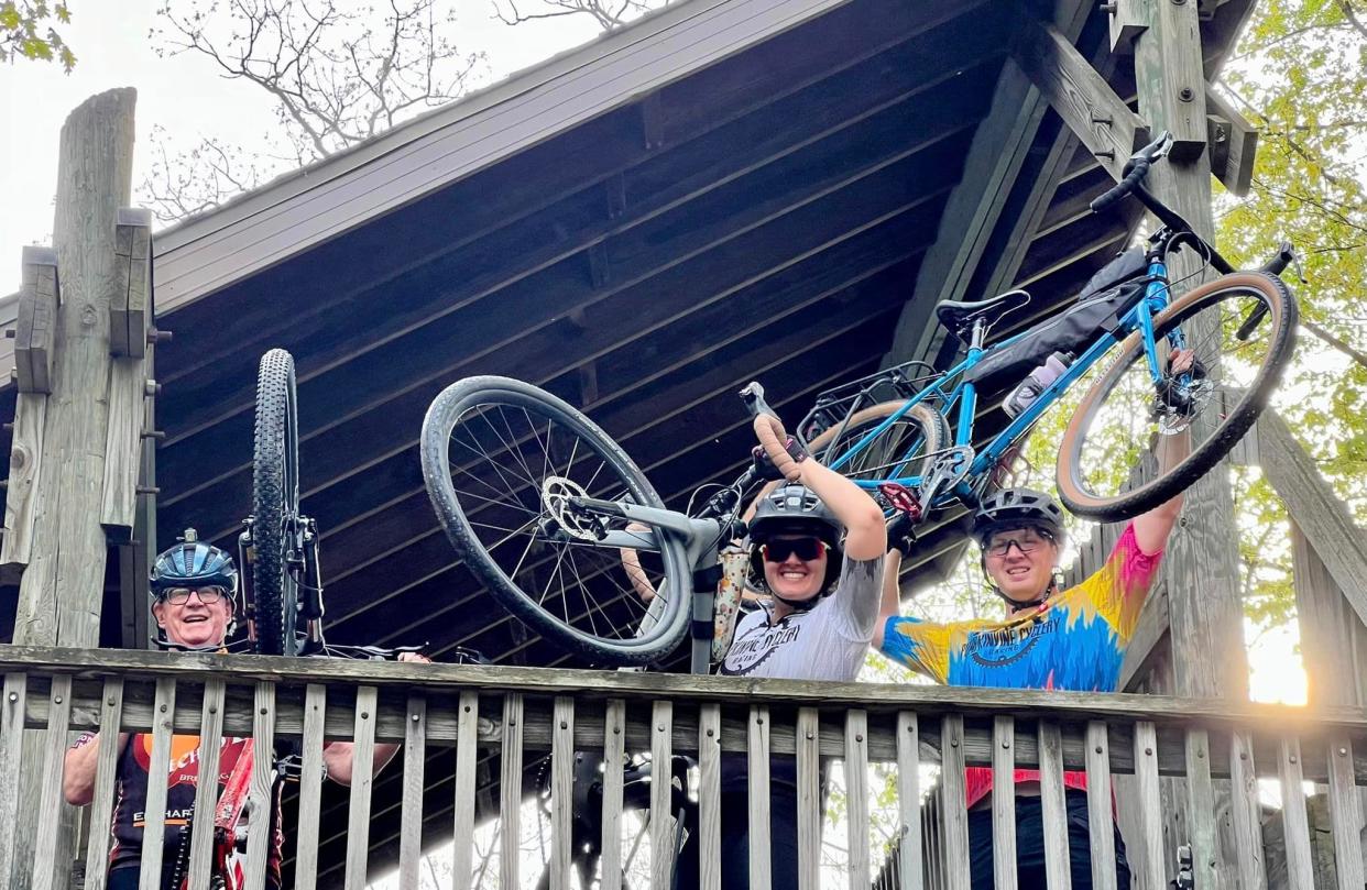 Cyclists hold up their bikes at a shelter at Madeline Bertrand County Park in Niles during the debut of The Rollout South Bend rides on May 2, 2024.