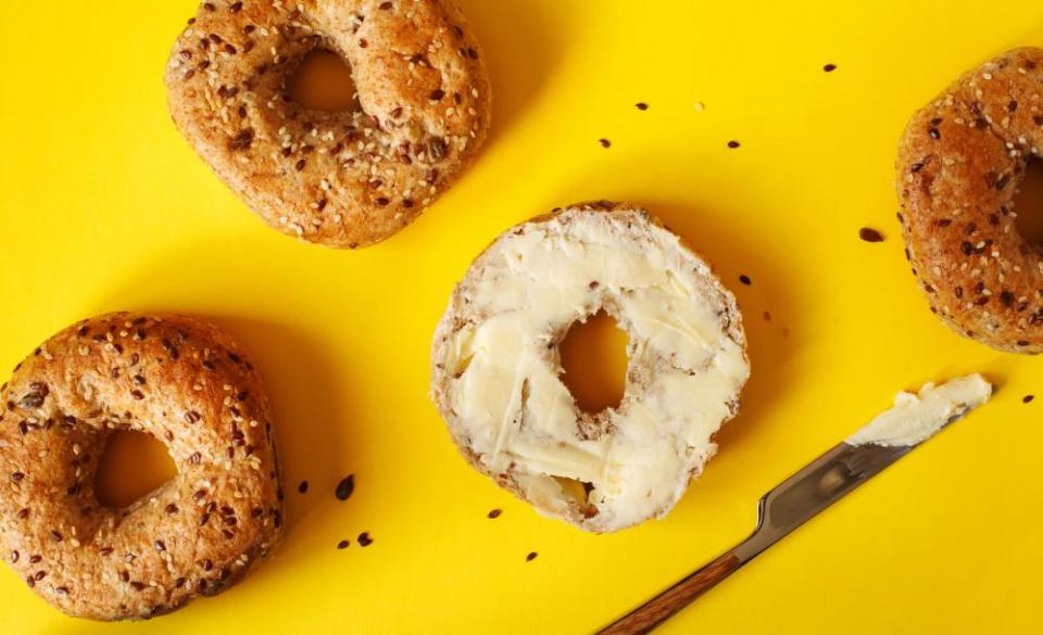 Closeup of 12-grain bagels, one with butter