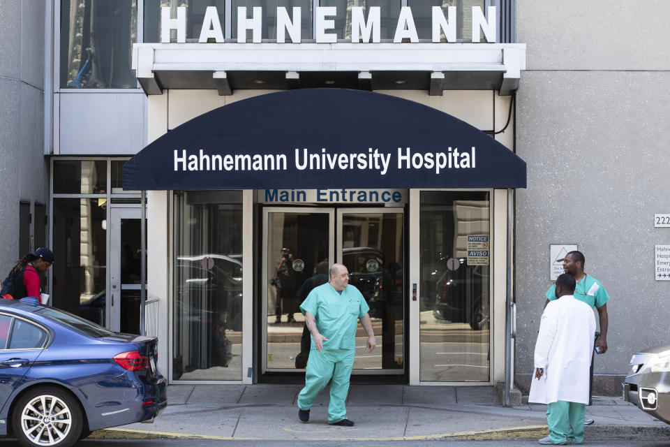 A person exits Hahnemann University Hospital in Philadelphia, Wednesday, June 26, 2019. The owner of hospital has announced it will close in September because of what the company calls "continuing, unsustainable financial losses." (AP Photo/Matt Rourke)