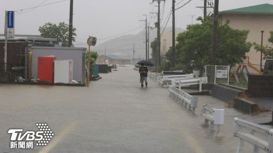 和歌山市民眾穿著雨鞋走在淹水的道路上。（圖／達志影像美聯社）