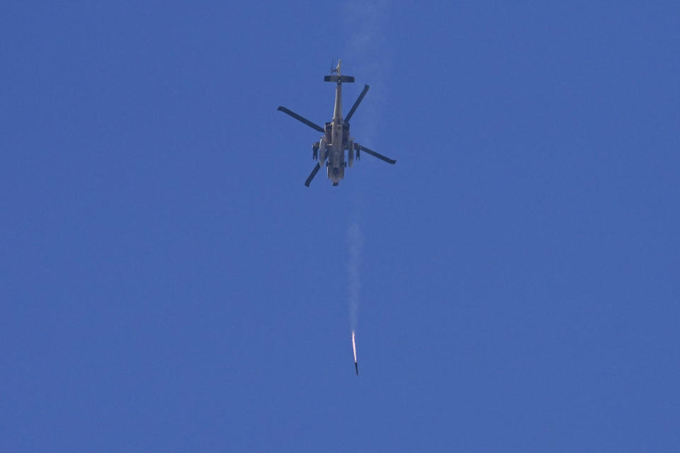 An Israeli Apache helicopter fires a missile in direction of the Gaza Strip, as seen from southern Israel, Monday, Dec. 4, 2023. (AP Photo/Ohad Zwigenberg)