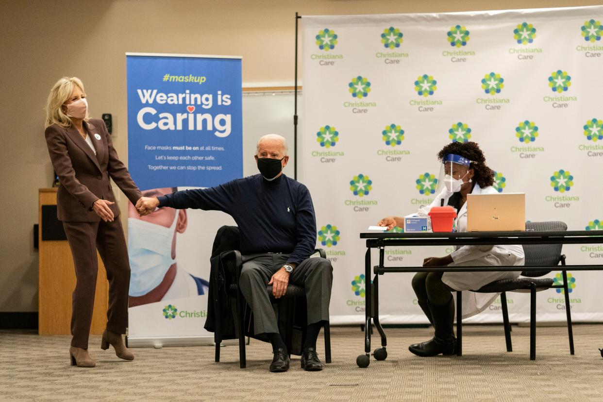 President-elect Joe Biden holds his wife Jill Biden's hand after receiving his first dose of the coronavirus vaccine from Tabe Mase at Christiana Hospital on live television in Newark, Del. on Monday, Dec. 21, 2020.