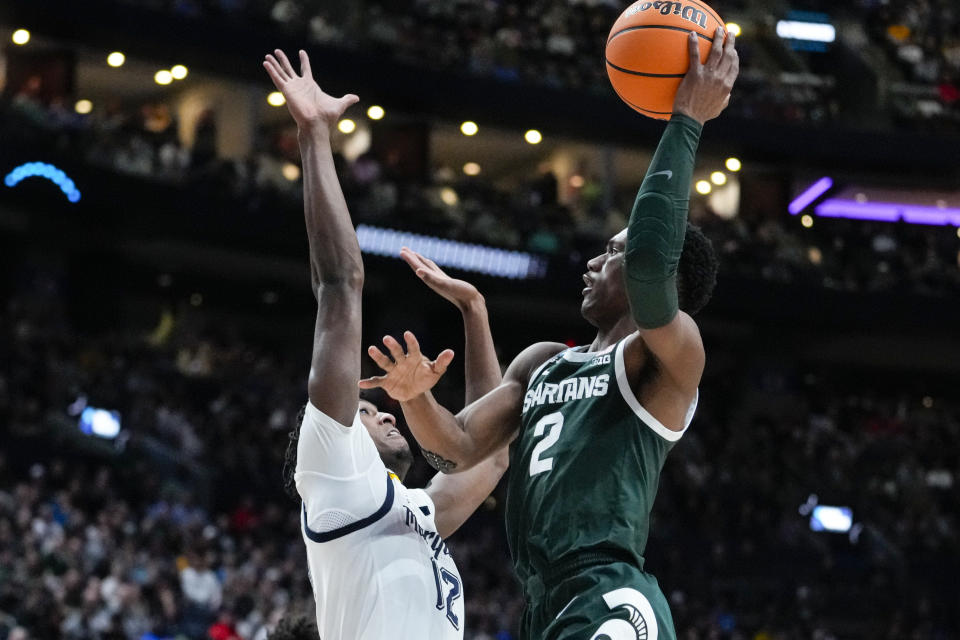 Michigan State guard Tyson Walker (2) shoots over Marquette forward Olivier-Maxence Prosper (12) in the second half of a second-round college basketball game in the men's NCAA Tournament in Columbus, Ohio, Sunday, March 19, 2023. (AP Photo/Michael Conroy)