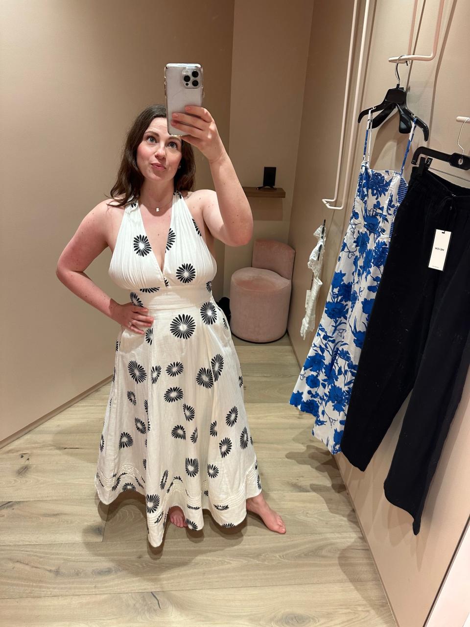 A woman takes a mirror selfie in a dressing room.