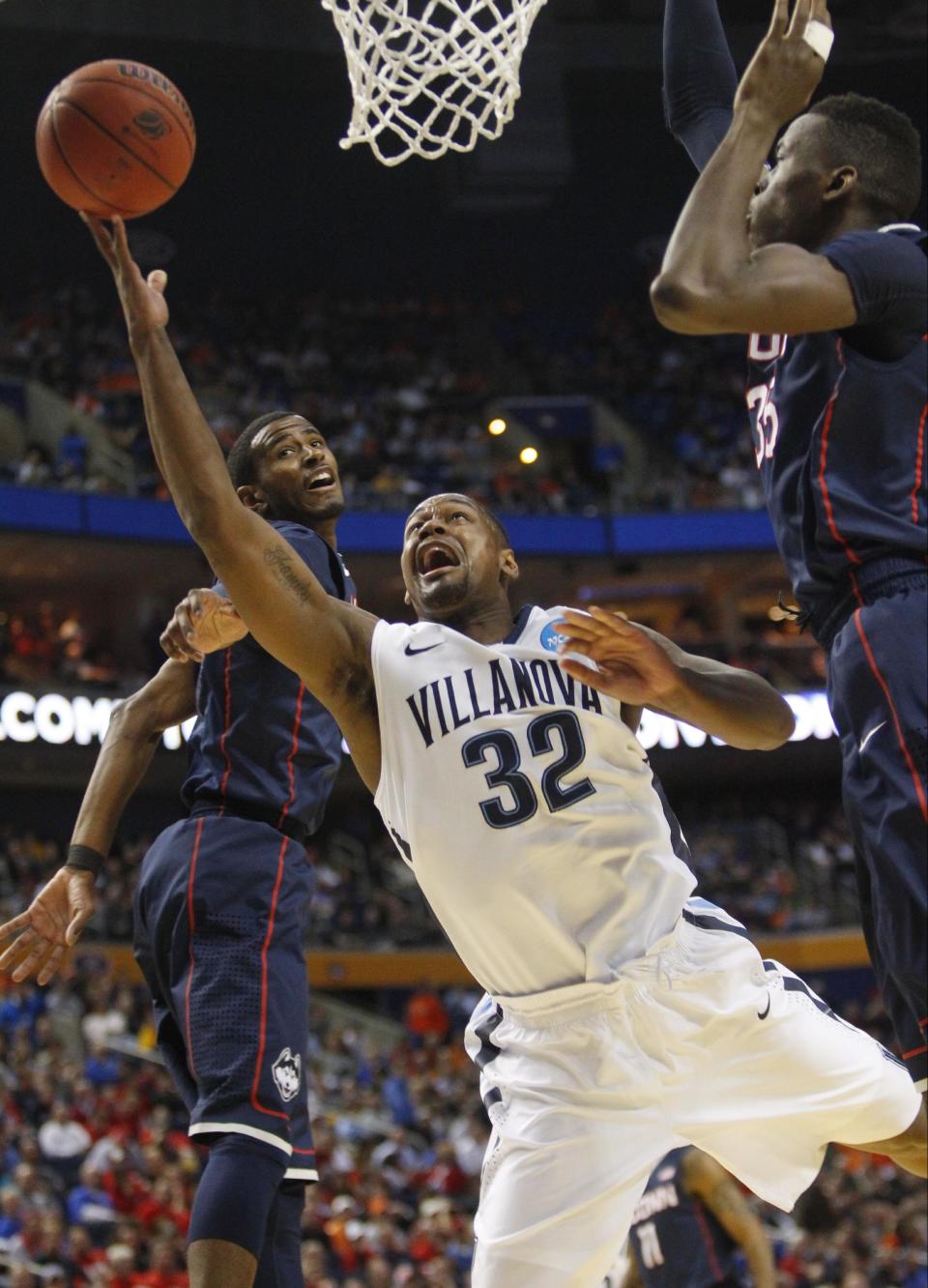 Villanova's James Bell (32) drives past Connecticut's Amida Brimah (35) during the first half of a third-round game in the NCAA men's college basketball tournament in Buffalo, N.Y., Saturday, March 22, 2014. (AP Photo/Bill Wippert)