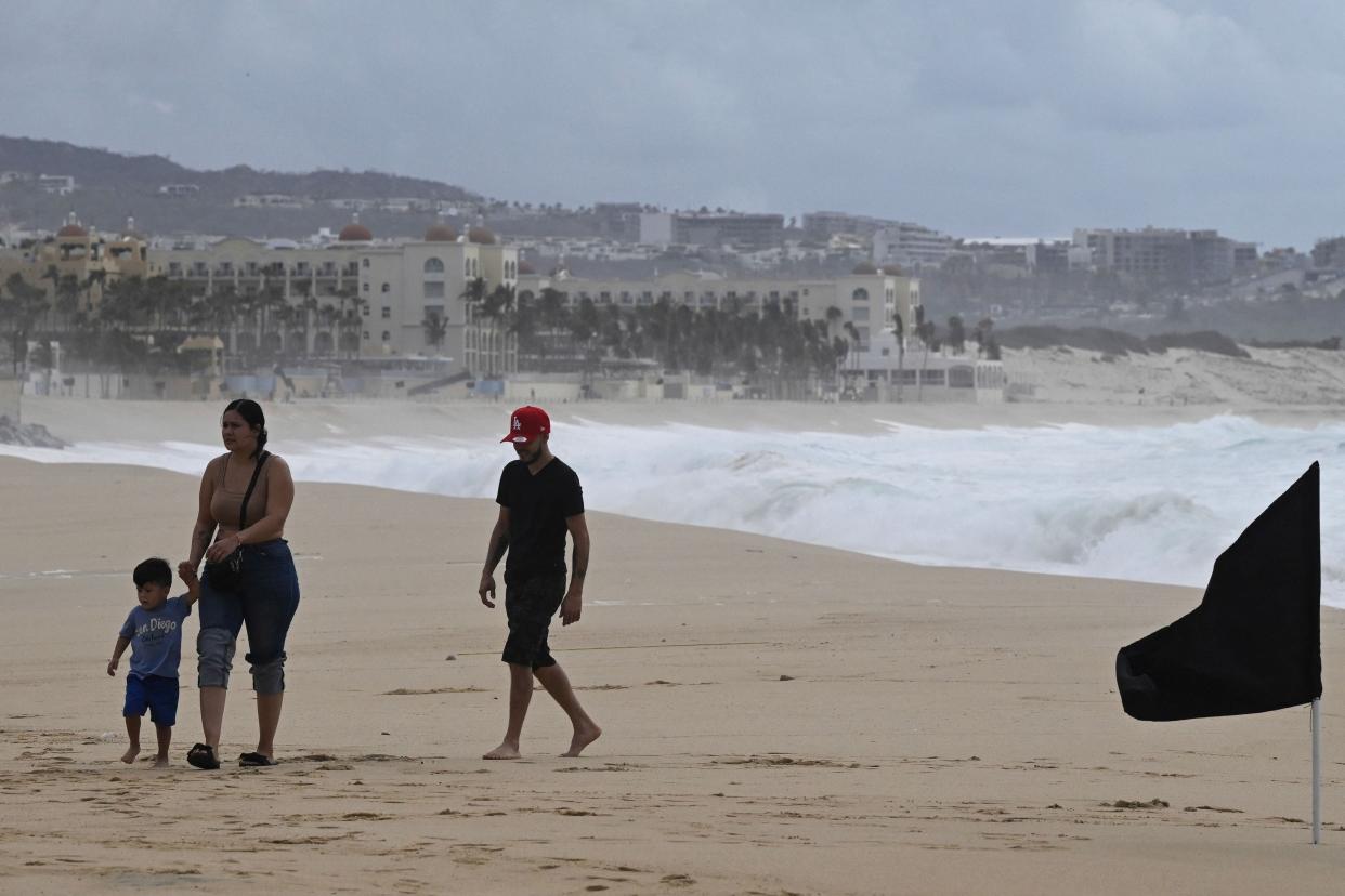 A family walks on the Medano beach before the arrival of hurricane Hilary at Los Cabos resort in Baja California state, Mexico on August 18, 2023. (AFP via Getty Images)