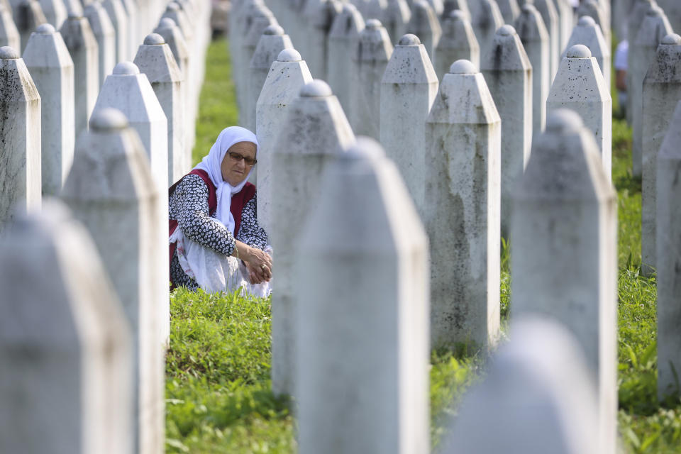 A Bosnian muslim woman mourns next to the grave of her relative, victim of the Srebrenica genocide, in Memorial Centre in Potocari, Bosnia, Tuesday, July 11, 2023. Thousands gather in the eastern Bosnian town of Srebrenica to commemorate the 28th anniversary on Monday of Europe's only acknowledged genocide since World War II. (AP Photo/Armin Durgut)
