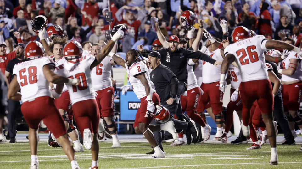 North Carolina State players and coaches celebrate after North Carolina missed a field-goal attempt in the second overtime, giving North Carolina State a 30-27 win in an NCAA college football game Friday, Nov. 25, 2022, in Chapel Hill, N.C. (AP Photo/Chris Seward)