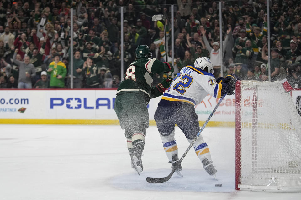 Minnesota Wild right wing Ryan Hartman, left, scores a goal past St. Louis Blues defenseman Justin Faulk during the first period of an NHL hockey game, Saturday, April 8, 2023, in St. Paul, Minn. (AP Photo/Abbie Parr)