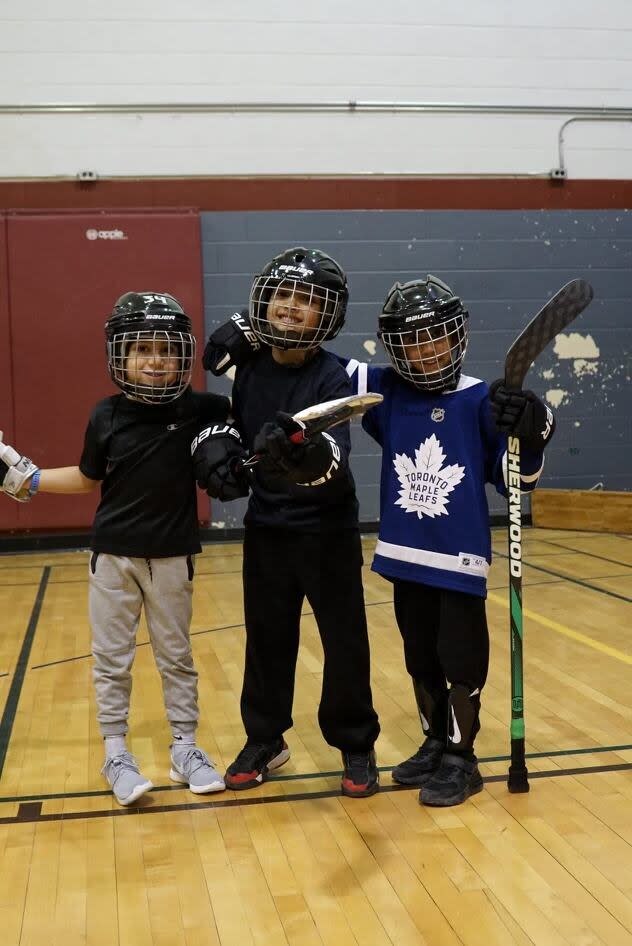 From left to right: Yusuf, Adam and Talib, participants in the Thorncliffe Ball Hockey League, pose for the camera. The league has more than 100 kids signed up for the winter session.  (Submitted by Huzaifa Jogiat  - image credit)