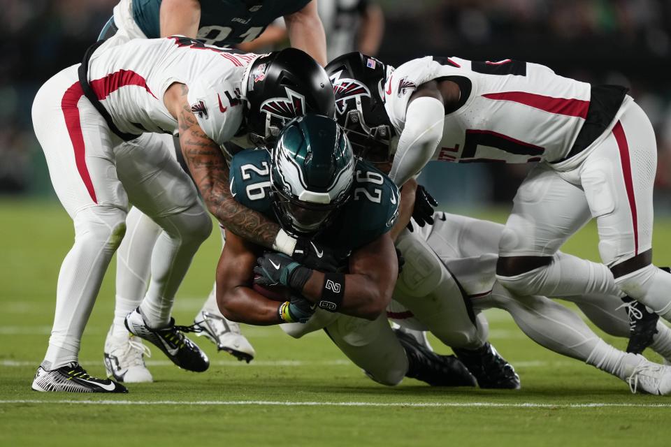 Philadelphia Eagles running back Saquon Barkley (26) is brought down during the first half of an NFL football game by Atlanta Falcons' Jessie Bates III, left, on Monday, Sept. 16, 2024, in Philadelphia. (AP Photo/Matt Slocum)