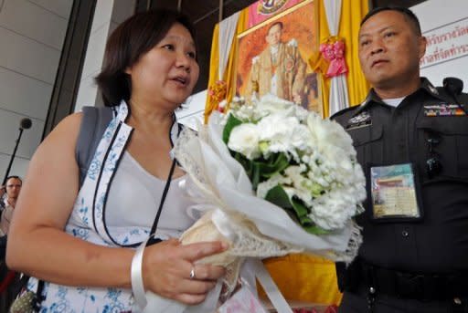 The editor of the popular Prachatai news website, Chiranuch Premchaiporn is escorted by police at the Criminal Court in Bangkok, on April 30. The court postponed giving its verdict in the closely-watched trial of the editor, accused over remarks about the monarchy posted by other people on her website