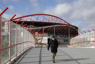 A man wearing a face mask walks outside the SL Benfica stadium in Lisbon, Monday, Nov. 29, 2021. Portuguese health authorities on Monday identified 13 cases of omicron, the new coronavirus variant spreading fast globally, among members of the Lisbon-based Belenenses SAD soccer club, and were investigating possible local transmission of the virus outside of southern Africa. Benfica, which played Belenenses on Saturday, said that its players were tested on Monday as they normally are every week and that results were expected later in the day. (AP Photo/Ana Brigida)