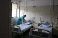 Medical staff check an empty ward, reserved for possible COVID-19 patients, at the Colentina Hospital in Bucharest, Romania, Thursday, Feb. 25, 2021. A year ago, Romania reported its first case of COVID-19, prompting the country's strapped medical system to turn its focus to treating COVID-19 patients. As a result, many patients with other conditions — including HIV but also cancer and other illnesses — have either been denied critical care or stopped going to their regular appointments, fearful of becoming infected.(AP Photo/Vadim Ghirda)