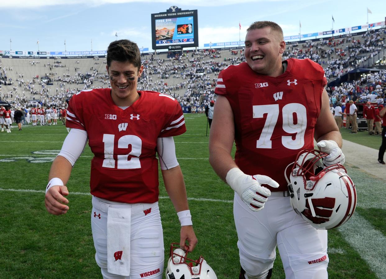 Alex Hornibrook (L) and teammate David Edwards walk off the field after their 40-6 win over the Brigham Young Cougars. (Photo by Gene Sweeney Jr/Getty Images)