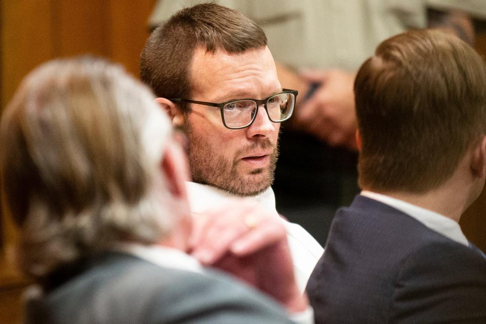 Michael Lang, center, speaks to his attorneys during his trial at the Hamilton County Courthouse on Thursday.