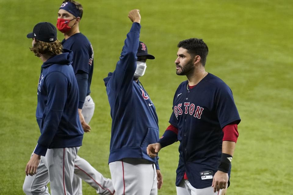 Boston Red Sox manager Alex Cora, center, and J.D. Martinez, right, celebrate the team's 6-1 win in a baseball game against the Texas Rangers in Arlington, Texas, Friday, April 30, 2021. (AP Photo/Tony Gutierrez)