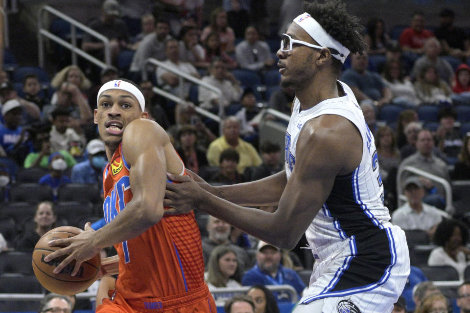 Oklahoma City Thunder forward Darius Bazley (7) drives to the basket in front of Orlando Magic center Wendell Carter Jr., right, during the first half of an NBA basketball game, Sunday, March 20, 2022, in Orlando, Fla. (AP Photo/Phelan M. Ebenhack)