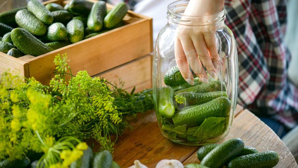 young woman makes homemade pickled cucumber preparations