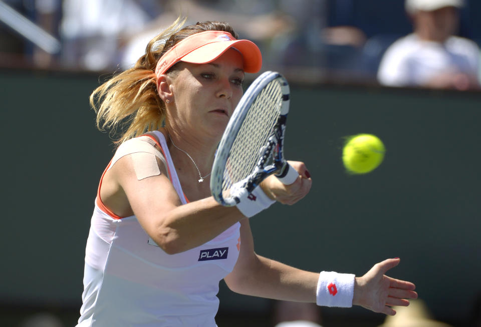 Agnieszka Radwanska, of Poland, returns a shot from Flavia Pennetta, of Italy, in their final round at the BNP Paribas Open tennis tournament, Sunday, March 16, 2014, in Indian Wells, Calif. (AP Photo/Mark J. Terrill)