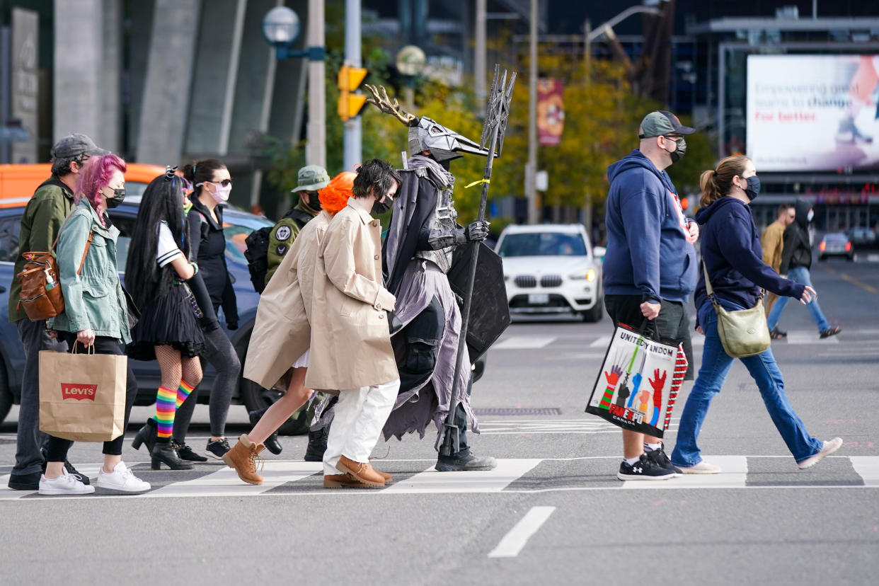 A cosplayer crosses the street to FAN EXPO Canada: LIMITED EDITION in Toronto on Saturday, Oct. 23, 2021. THE CANADIAN PRESS/Evan Buhler