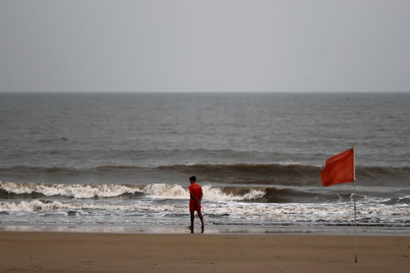 Lifeguard walks along the shore off the Arabian Sea before cyclone Nisarga makes its landfall, in Mumbai