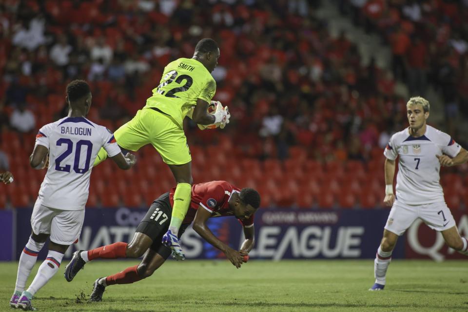 Trinidad and Tobago goalkeeper Denzil Smith, center, catches a shot from United States' Giovanni Reyna, right, during a CONCACAF Nations League quarterfinal soccer match at Hasely Crawford Stadium in Port of Spain, Trinidad and Tobago, Monday, Nov. 20, 2023. (AP Photo/Azlan Mohammed)