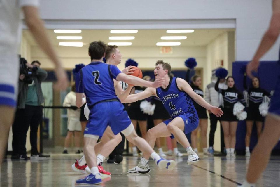 Lexington Catholic’s Sam Smith (2) and John Reinhart (4) trap a Lexington Christian player during the Knights’ 55-42 win over LCA in the boys 43rd District Tournament championship game at Lexington Christian Academy on Friday.