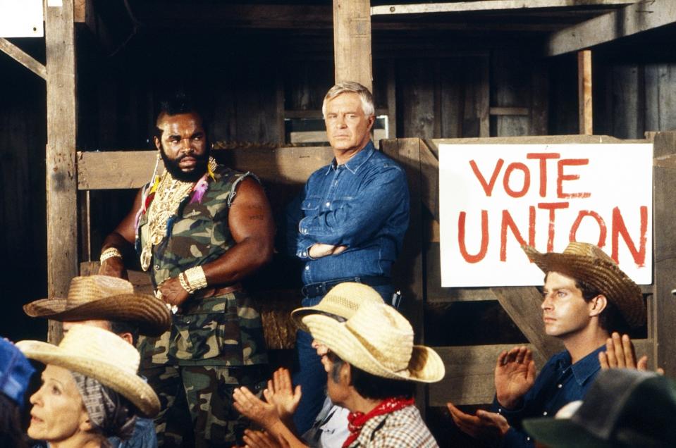 Mr. T and George Peppard eye a room full of cowboys