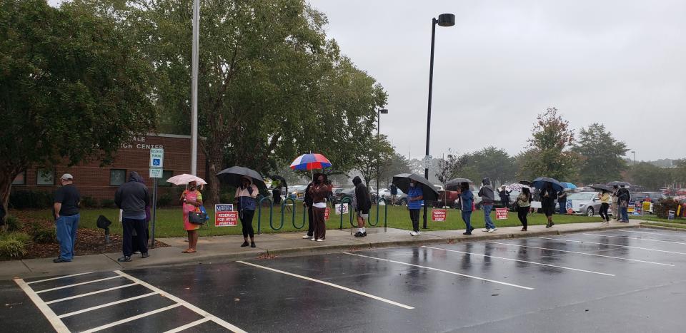 Voters wait in the rain just before 10 a.m. at the Cliffdale Recreation Center early voting site in Fayetteville on Friday, Oct. 16, 2020. Cumberland County election officials reported on Facebook that more than 10,400 people had voted on Thursday, the first day of early voting in North Carolina for the Nov. 3 election. Early voting continues each day through Oct. 31.