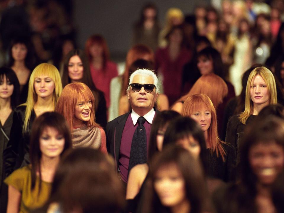 Karl Lagerfeld surrounded by models on runway