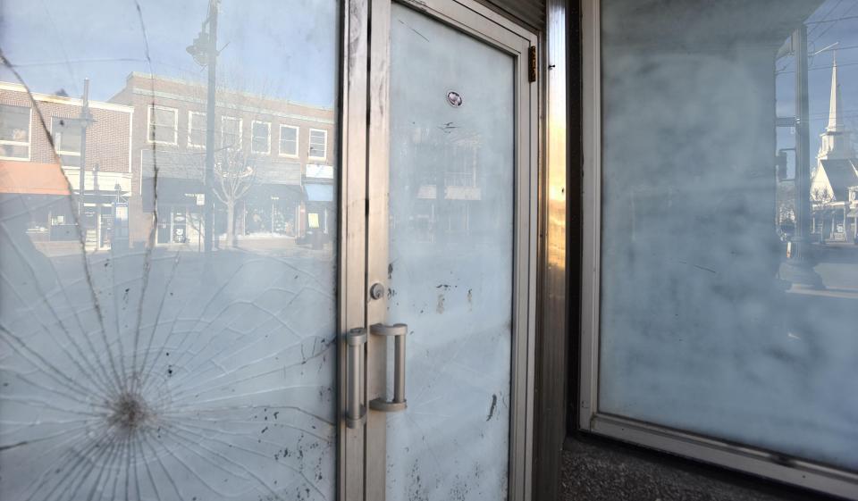 Hyannis Main Street reflects up in the shattered glass of an unoccupied building along the 300 block of the street.