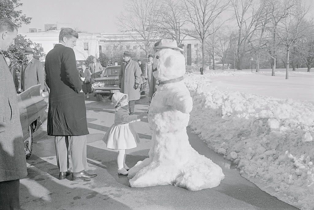 john f kennedy and daughter caroline admiring snowman