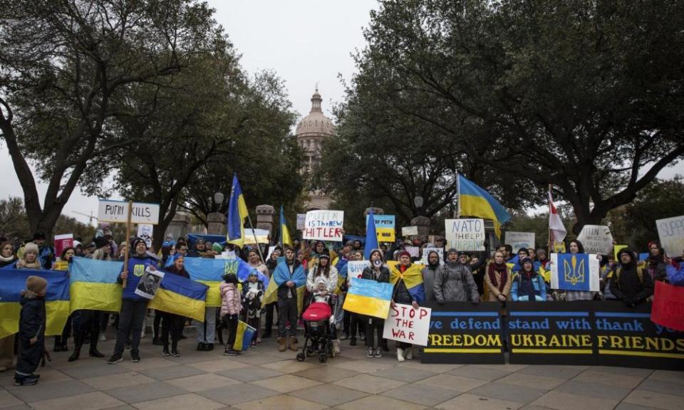 Group of people standing with yellow and blue flags and posters