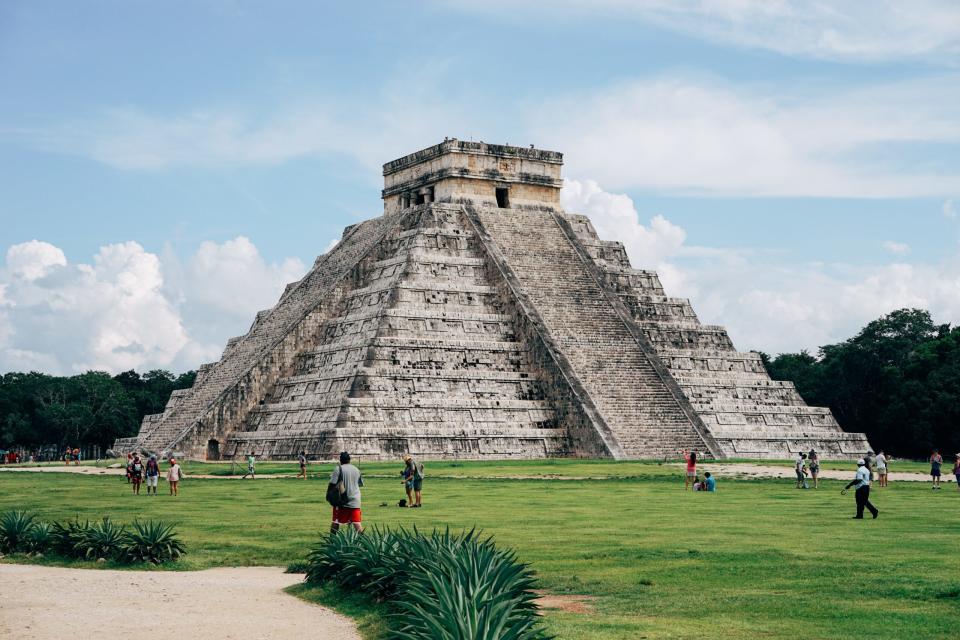 This popular pyramid, Chichén Itzá (or Castillo), is known for its towering height.
pictured: The grand Castillo Pyramid with visitors walking around the surrounding area 