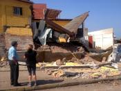 Una pareja ante una casa destrozada por el potente terremoto de 8,2 grados en la escala Richter, que dejó seis muertos, daños materiales por calcular y a una población atemorizada, en Iquique (norte de Chile), el 2 de abril de 2014 (AFP | Aldo Solimano)