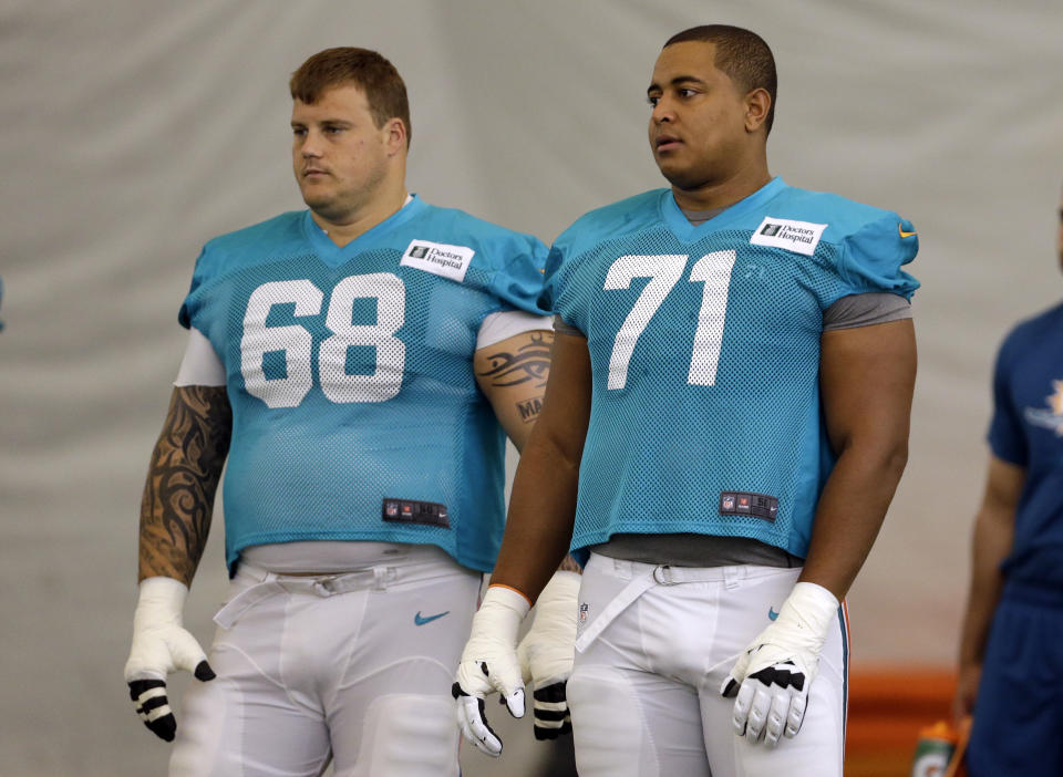 FILE - In this July 24, 2013 file photo, Miami Dolphins guard Richie Incognito (68) and tackle Jonathan Martin (71) stand on the field during an NFL football practice in Davie, Fla. The biggest professional sports leagues in the United States have dealt with a smattering of hazing issues over the past decade, ranging from NFL offensive lineman Richie Incognito's bad behavior to Major League Baseball cracking down on rookies dressing up as women. (AP Photo/Lynne Sladky, File)