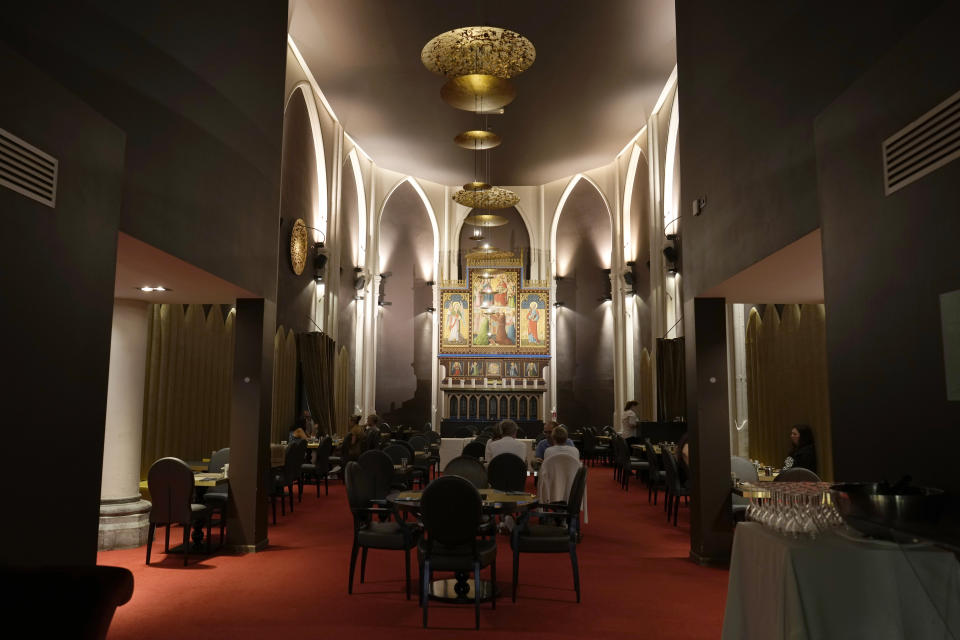 Guests eat breakfast in front of an altar that has been repurposed at the Martin's Patershof hotel in the center of Mechelen, Belgium, Monday, June 19, 2023. Across Europe, the continent that nurtured Christianity for most of two millennia, many churches, convents, beguinages and chapels stand empty as faith and church attendance have dwindled over the past half century. Many are now been repurposed to preserve their historical and architectural relevance, while others have opened up to non-religious activities to expand their use. (AP Photo/Virginia Mayo)