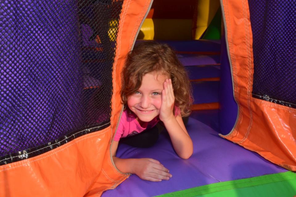 Olivia Cooper, 5, peeks out from an inflatable bouncy house at the 2019 Fall Carnival. Bouncy houses will be front and center at the Spring Fling April 14.