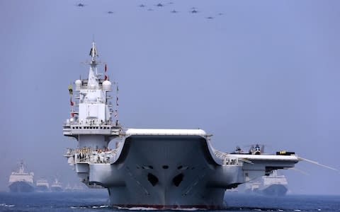 The aircraft carrier Liaoning and other vessels and fighter jets in the maritime parade conducted by the Chinese People's Liberation Army (PLA) Navy in the South China Sea on April 12 - Credit: China ilitary Online/ ZLSY