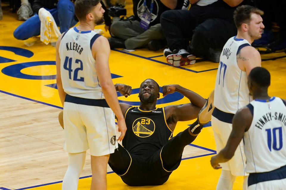 Golden State Warriors forward Draymond Green (23) reacts after scoring and being fouled behind Dallas Mavericks forward Maxi Kleber (42) and guard Luka Doncic, right, during the first half of Game 1 of the NBA basketball playoffs Western Conference finals in San Francisco, Wednesday, May 18, 2022. (AP Photo/Jeff Chiu)