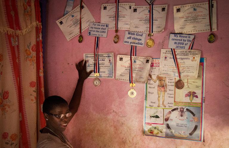 Overseas, Phiona Mutesi, pictured at home with her medals, has played against her hero, Russian former world champion and Grandmaster Garry Kasparov, and inspired school students in the US to start a tournament in her name