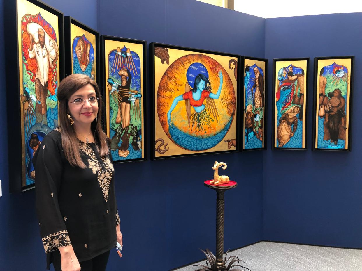 Artist Siona Benjamin stands next to her seven-panel piece "Exodus: I See Myself in You." The piece is part of her exhibit "Beyond Borders: The Art of Siona Benjamin" which is on display at Jewish Museum Milwaukee from June 17, 2022 until September 25, 2022.