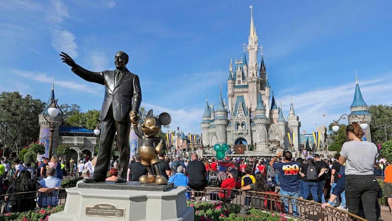 In this Jan. 9, 2019, photo, a statue of Walt Disney and Micky Mouse stands in front of the Cinderella Castle at the Magic Kingdom at Walt Disney World in Lake Buena Vista, Fla. Travis Larson, a resident of Riverton, Utah, modeled his basement after many of the attractions in Disney's Fantasyland.