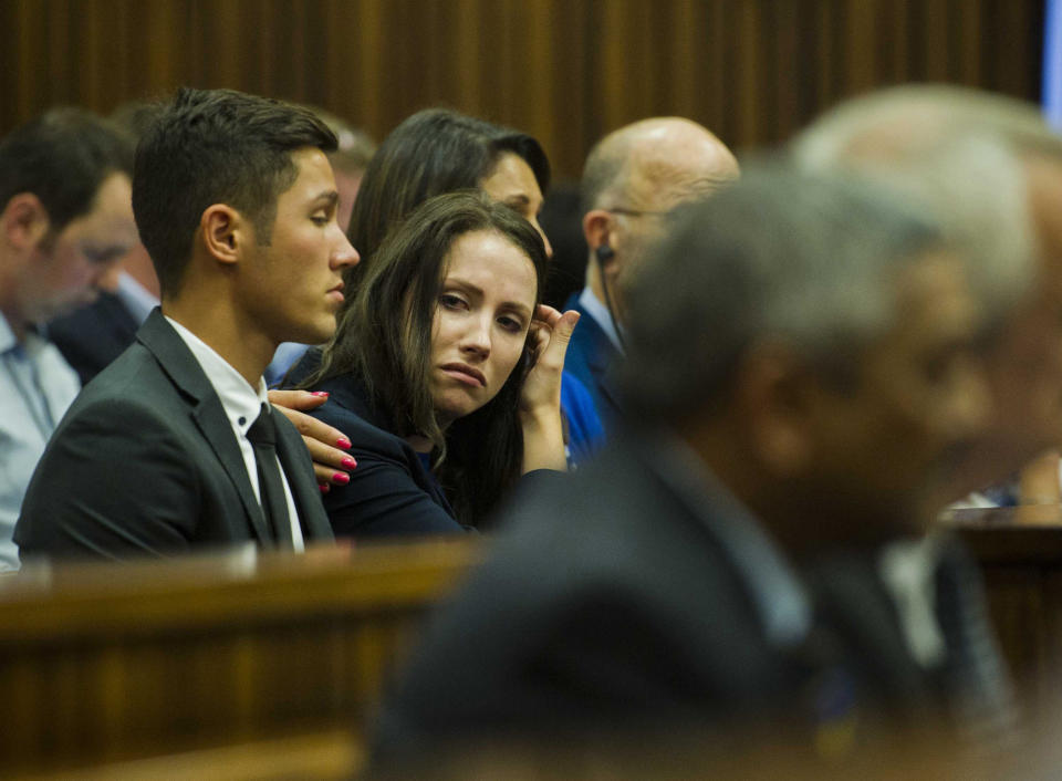 Sister of Oscar Pistorius, Aimee Pistorius, center, is comforted as she listens to forensic evidence during his trial in court in Pretoria, South Africa, Thursday March 13, 2014. Pistorius is charged with the shooting death of his girlfriend Reeva Steenkamp, on Valentines Day in 2013. (AP Photo/Alet Pretorius, Pool)