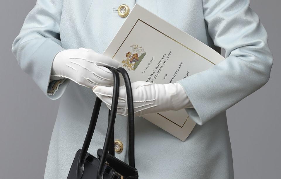 The Queen holds an order of service for the wedding.